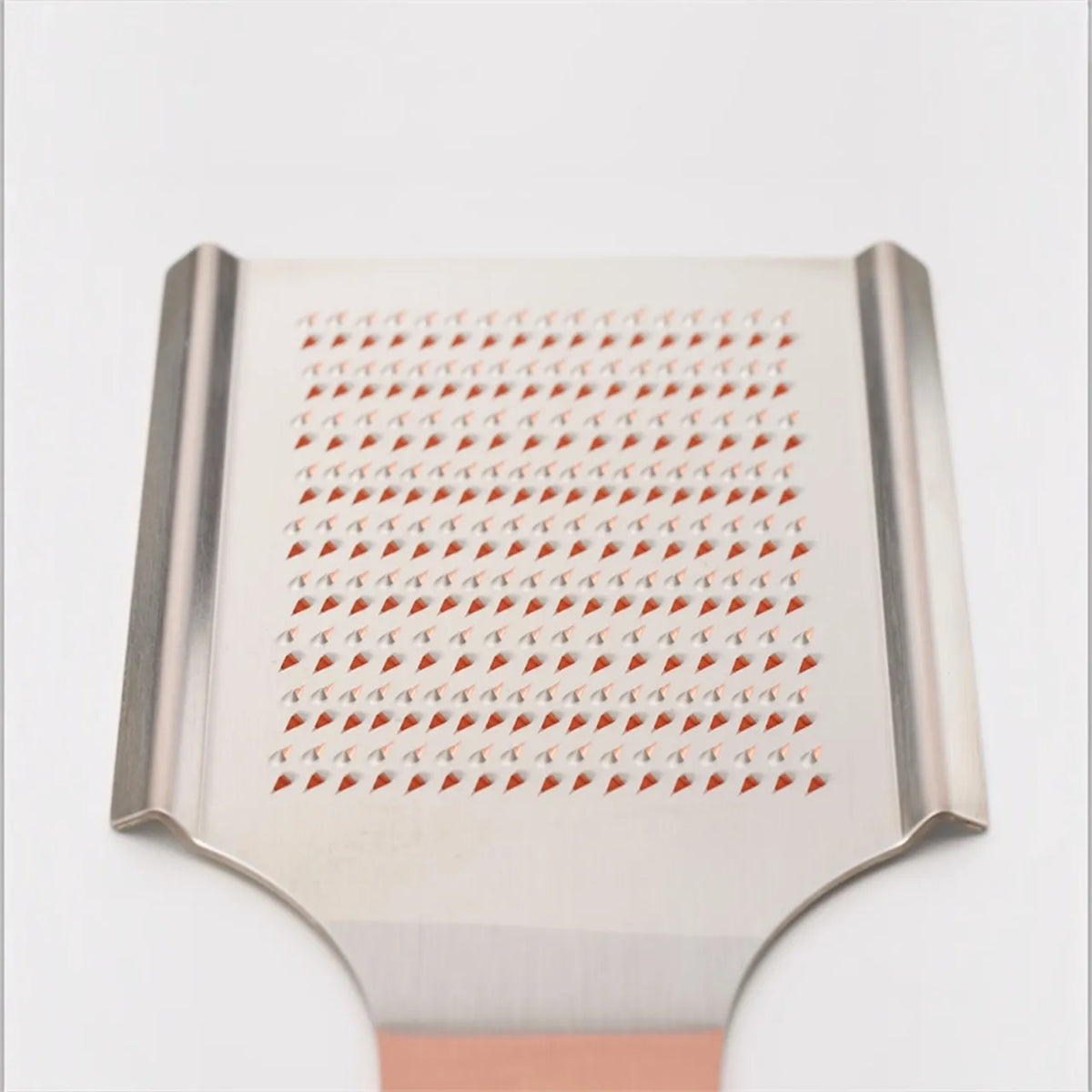 Close-up of hand-raised teeth on the copper grater