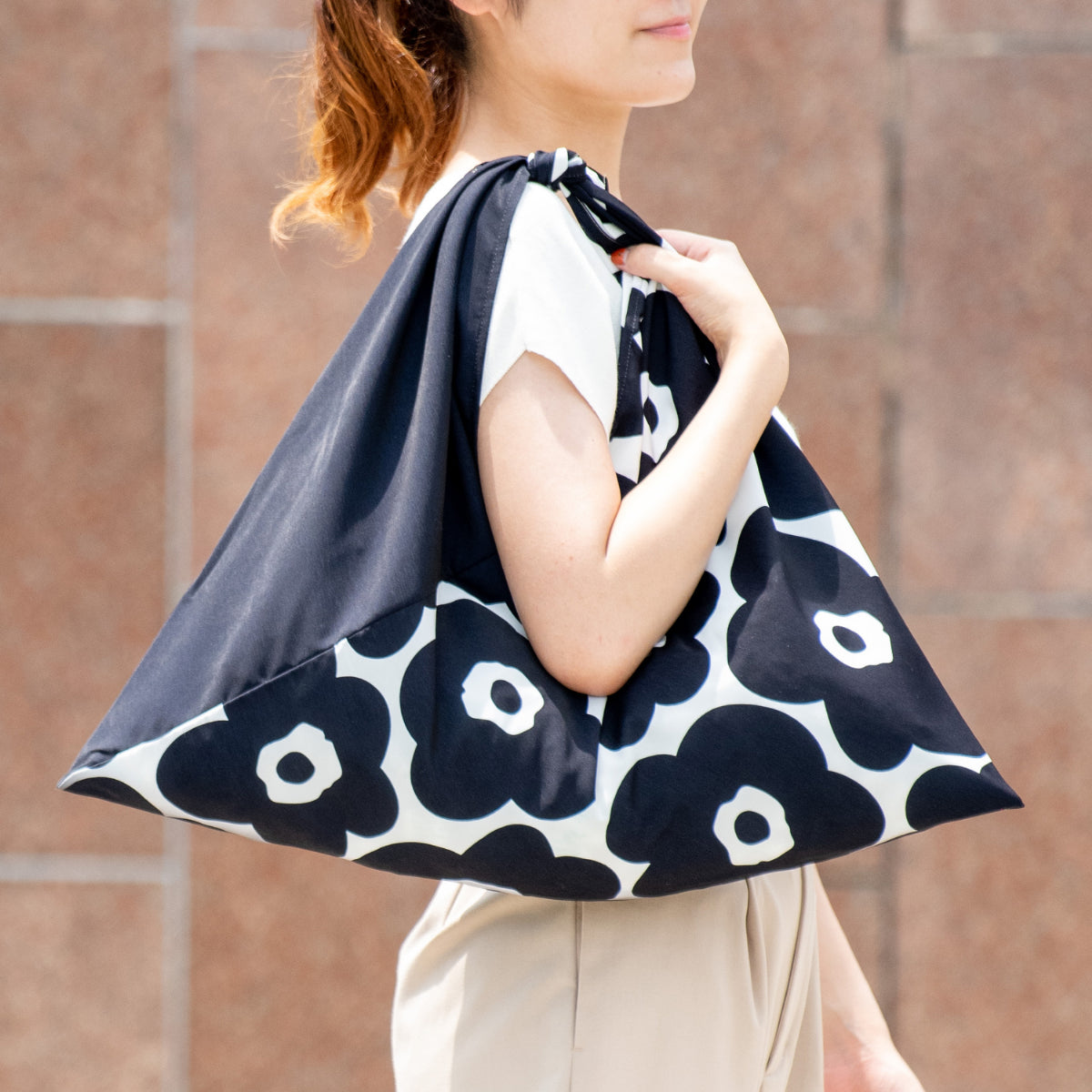 Woman carrying the AZUMA bag in Camellia Black on her shoulder #Pattern_Camellia Black