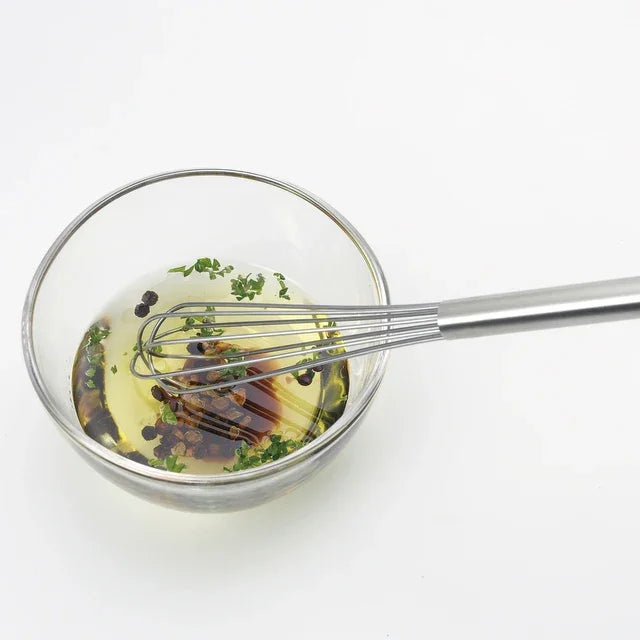 Mixing dressing in a glass bowl with the Mazelu whisk