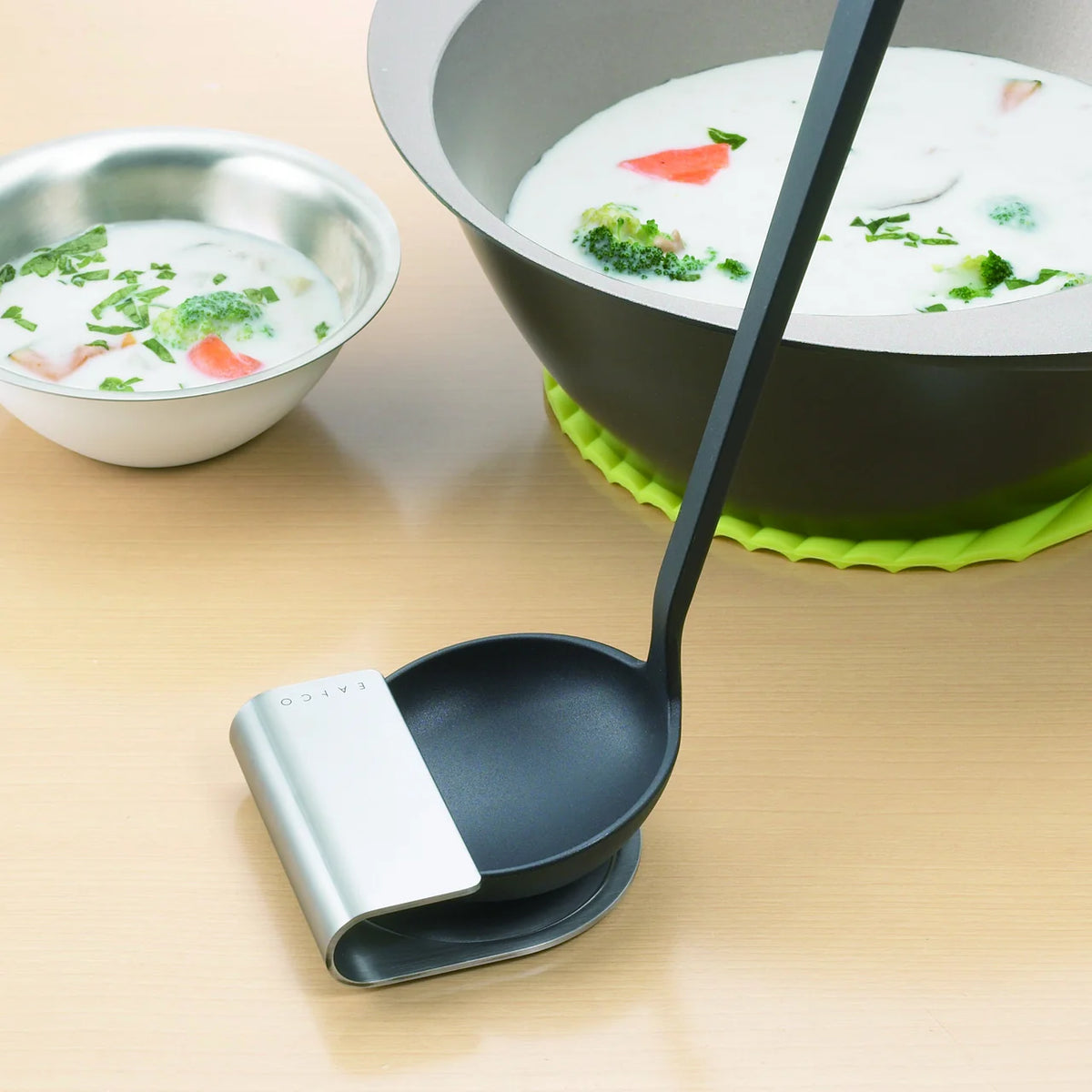 Black ladle resting on the Oki stand beside a pot