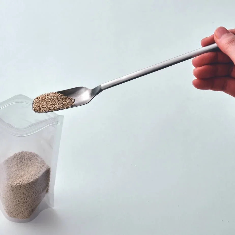 Scooping powder from a bag with Saji