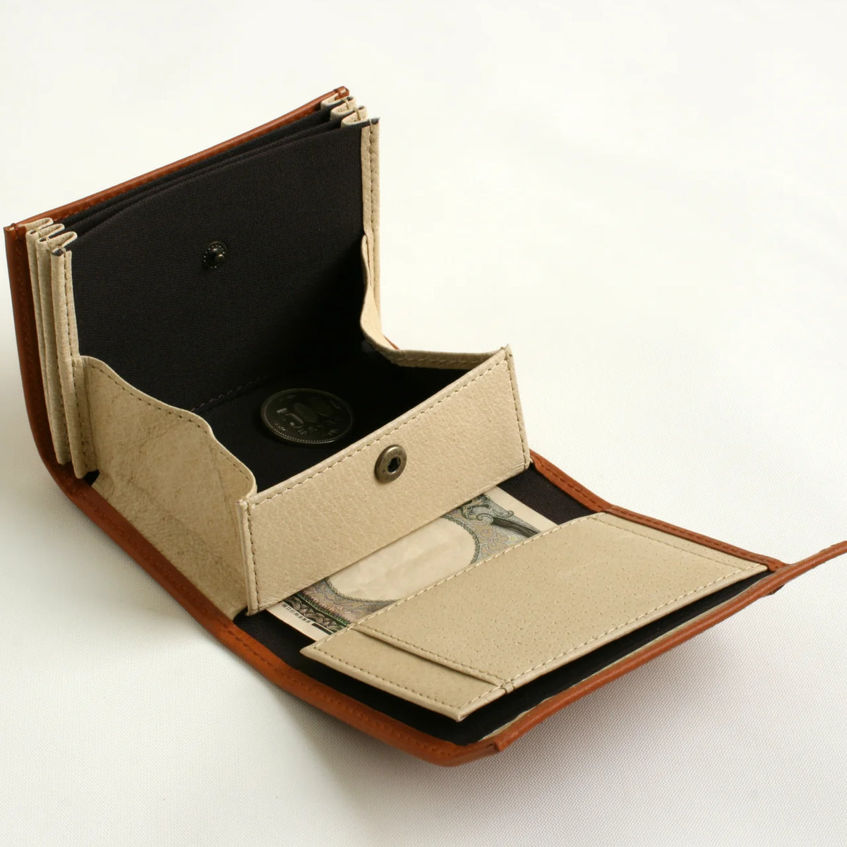 m+ millefoglie II wallet in cognac, opened to show the coin pocket and card slots