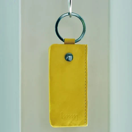 Yellow hmny key case hanging on a hook