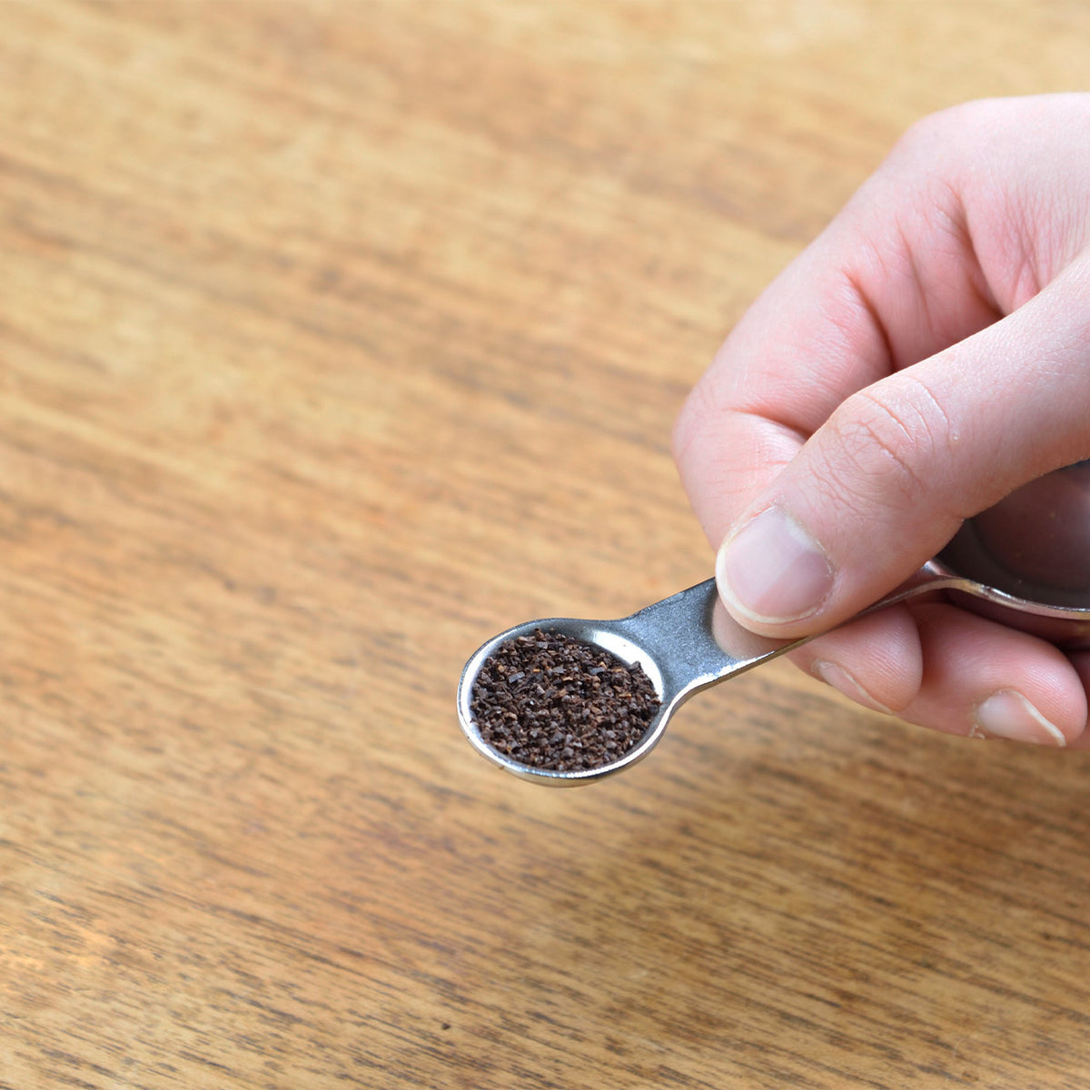 Measuring ground coffee with the 2-cup measure