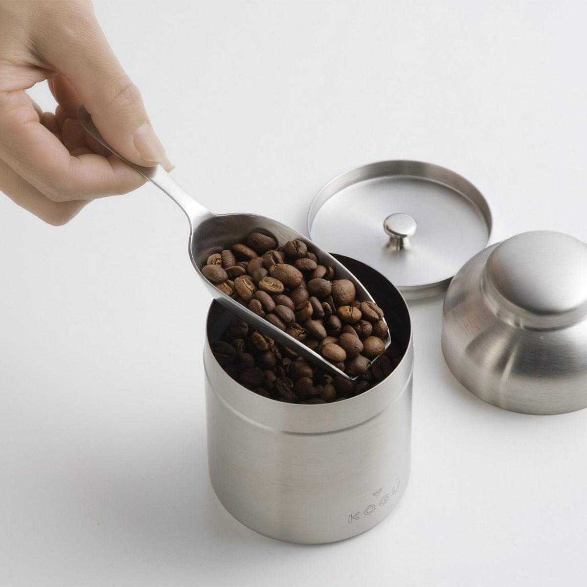 Scooping coffee beans from a stainless canister