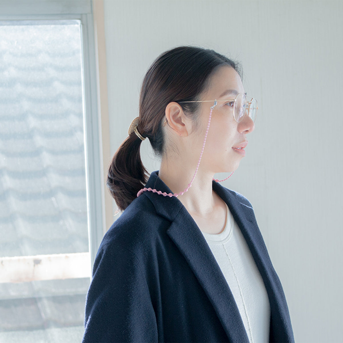 Woman in a navy jacket wearing the glasses cord