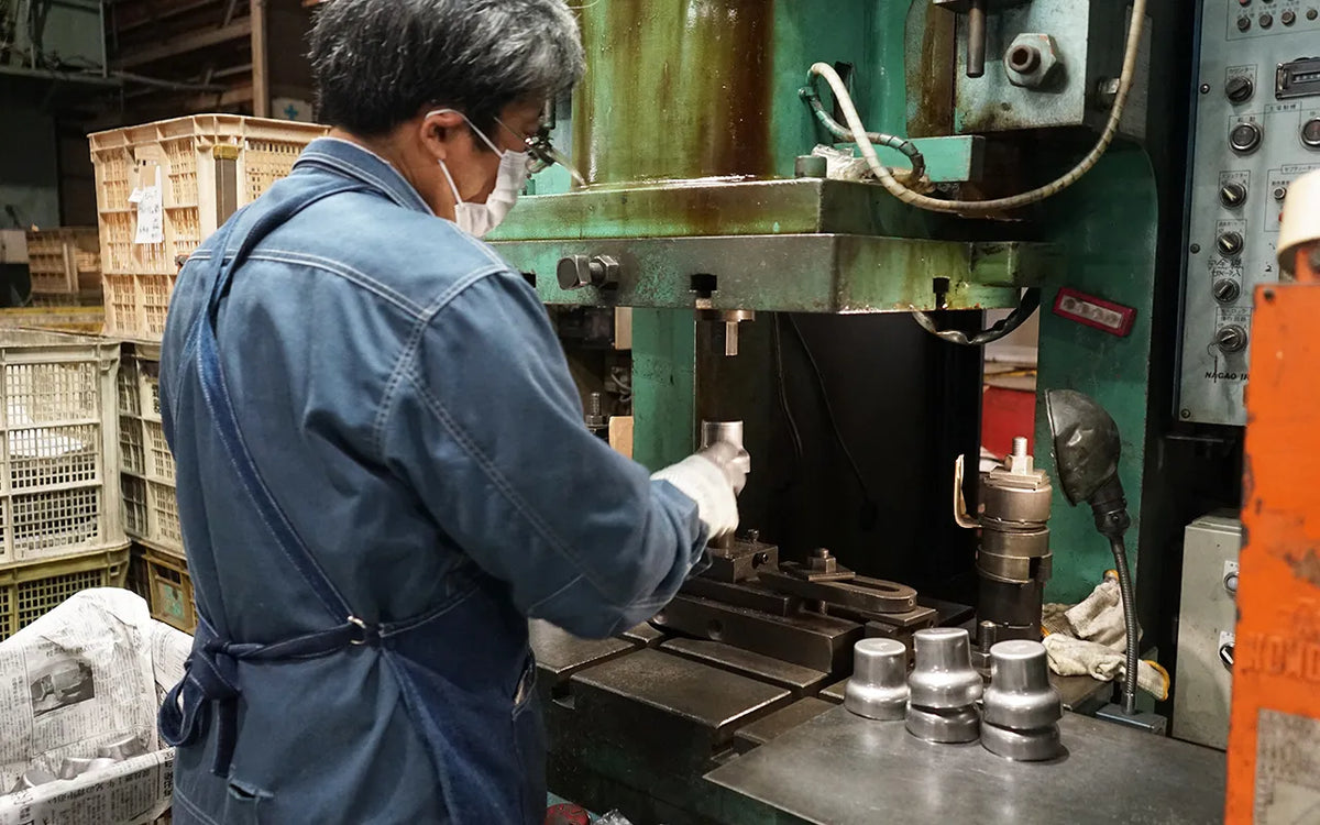 Kobo Aizawa craftsman working at the press