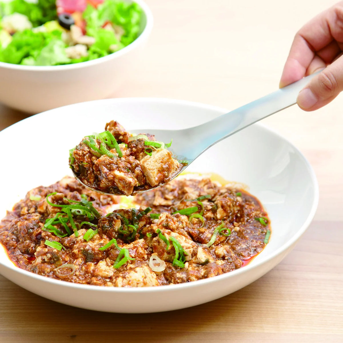 Serving a stew with the Suqu spoon