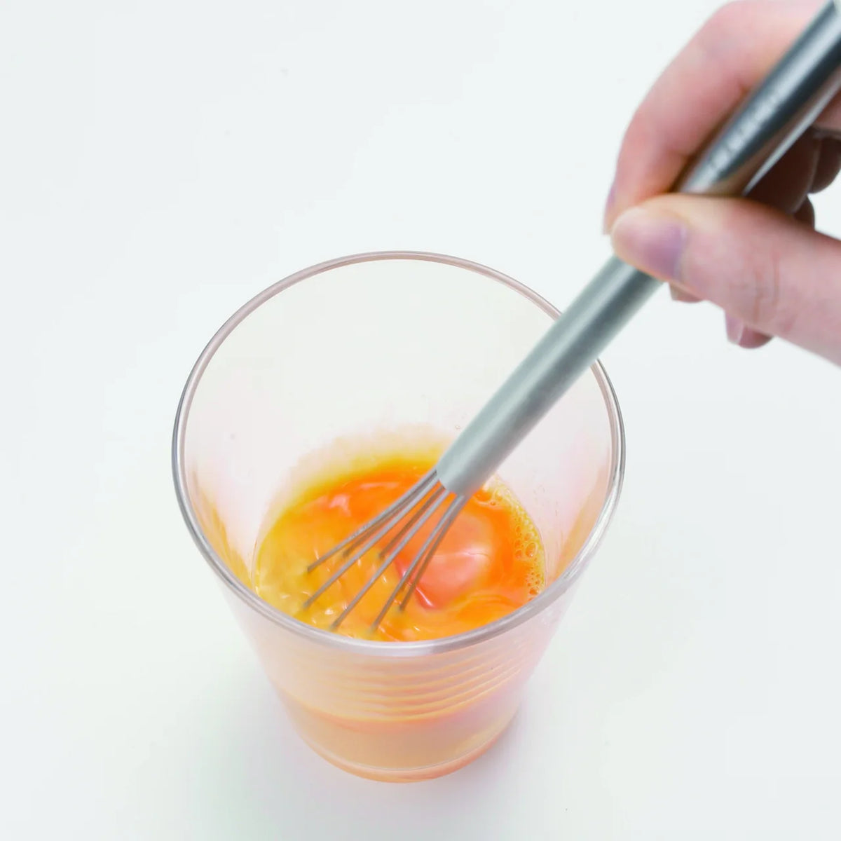 Whisking an egg in a glass with Mazelu