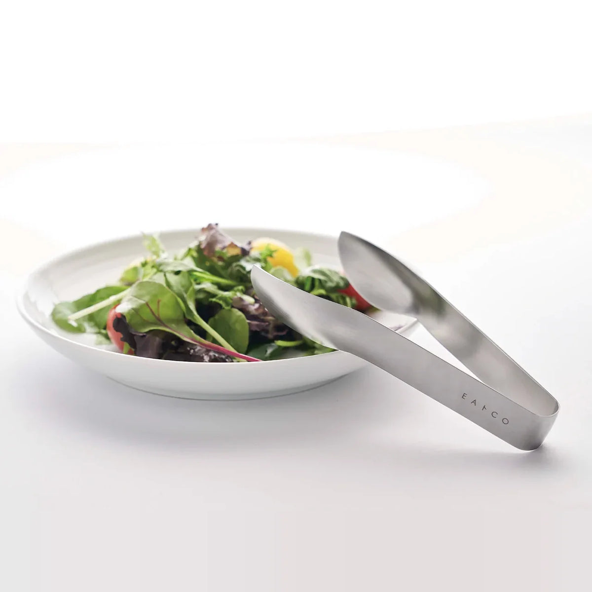 Serving salad from a plate with Hasam S tongs