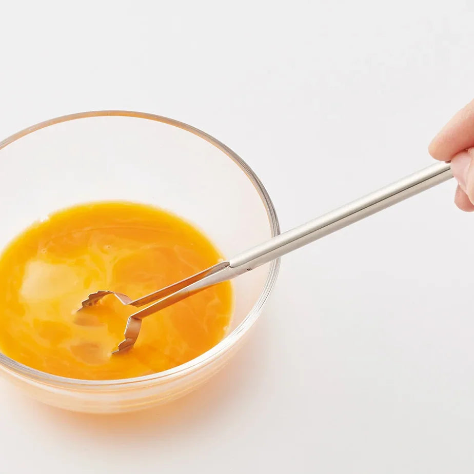 Beating egg yolks in a glass bowl with Toku