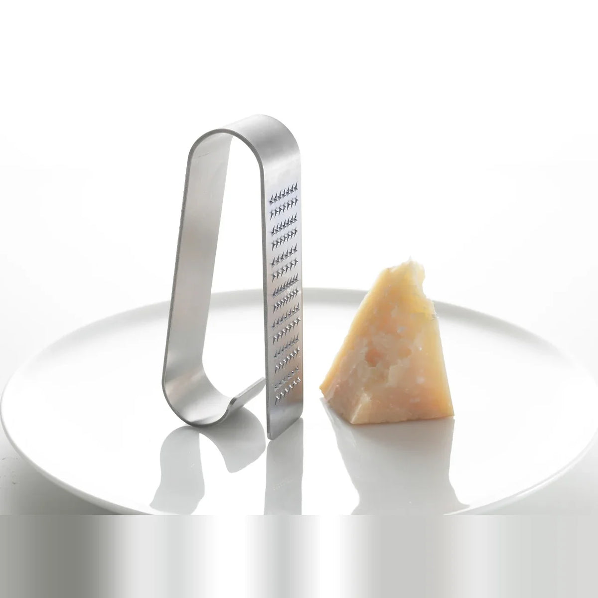 Oros Handy grater standing next to a piece of cheese