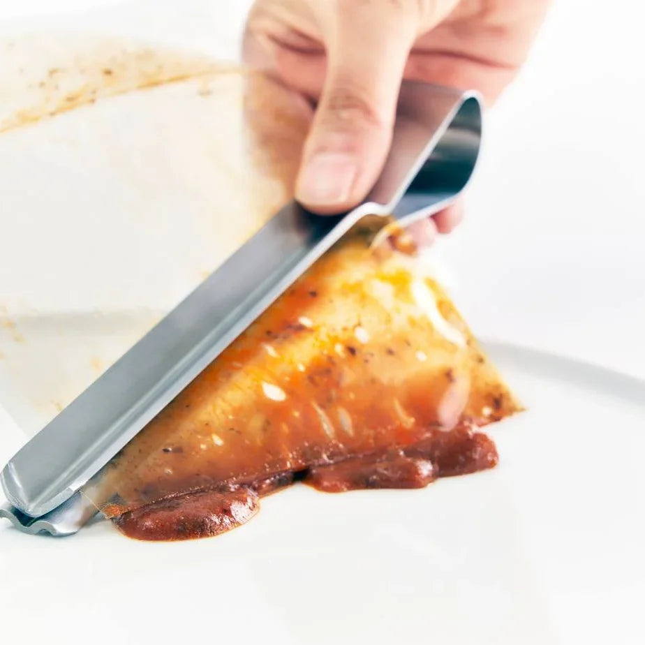 Shiboru tongs squeezing curry from a retort pouch