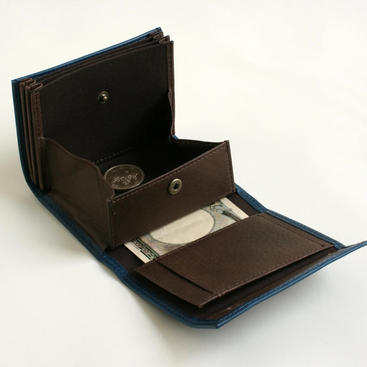 m+ millefoglie II wallet in blue, opened to show the coin pocket and card slots