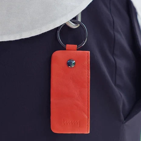 Orange hmny key case hanging from a belt loop
