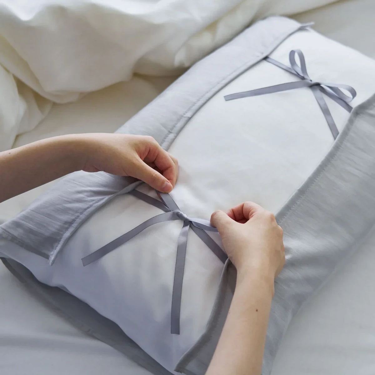 Tying the ribbons of the silk pillowcase around a pillow