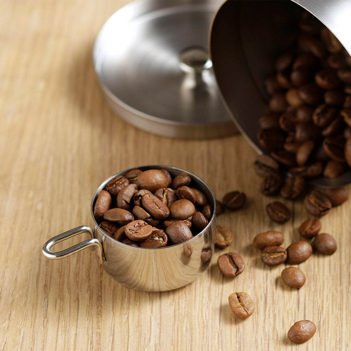 10g measure with coffee beans spilling from a canister
