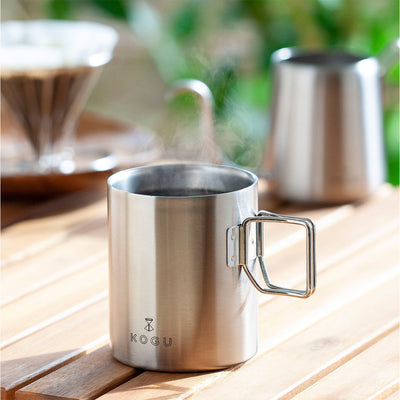 Double-walled stainless steel mugs on an outdoor table