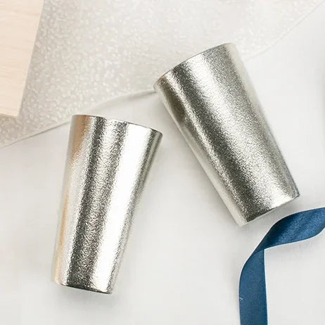 Two tin beer cups with a blue ribbon