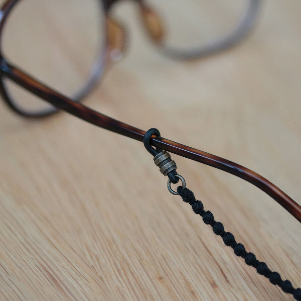 Close-up of the black cord attached to eyeglasses