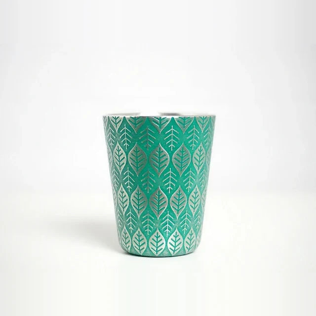Green Happa tin tumbler on a white table