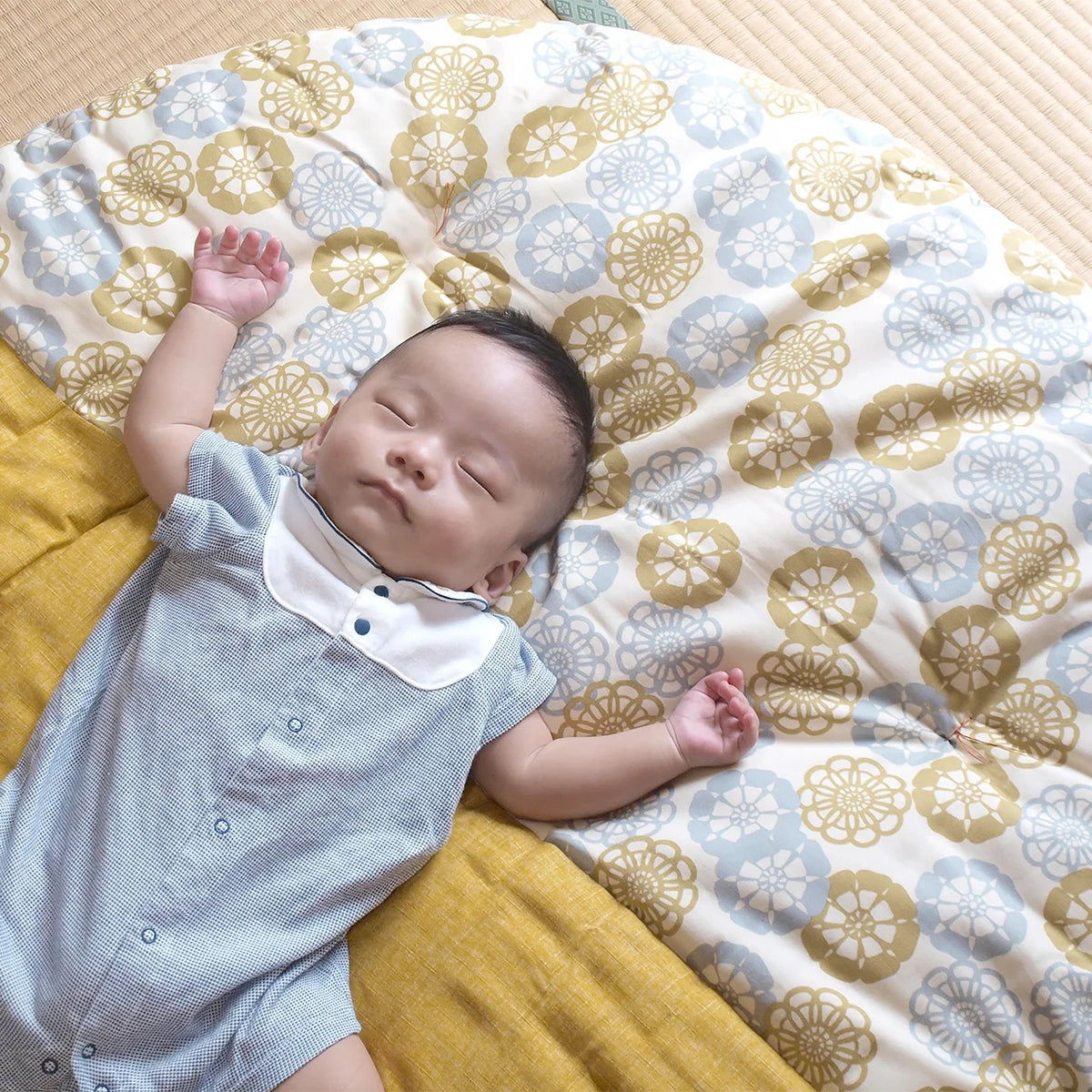 A baby napping on the senbei floor cushion